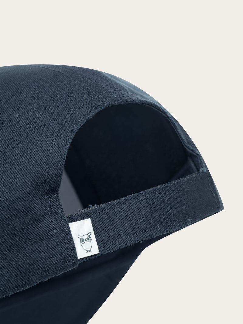 KnowledgeCotton Apparel - UNI Twill baseball cap with siliconebadge Caps 1001 Total Eclipse